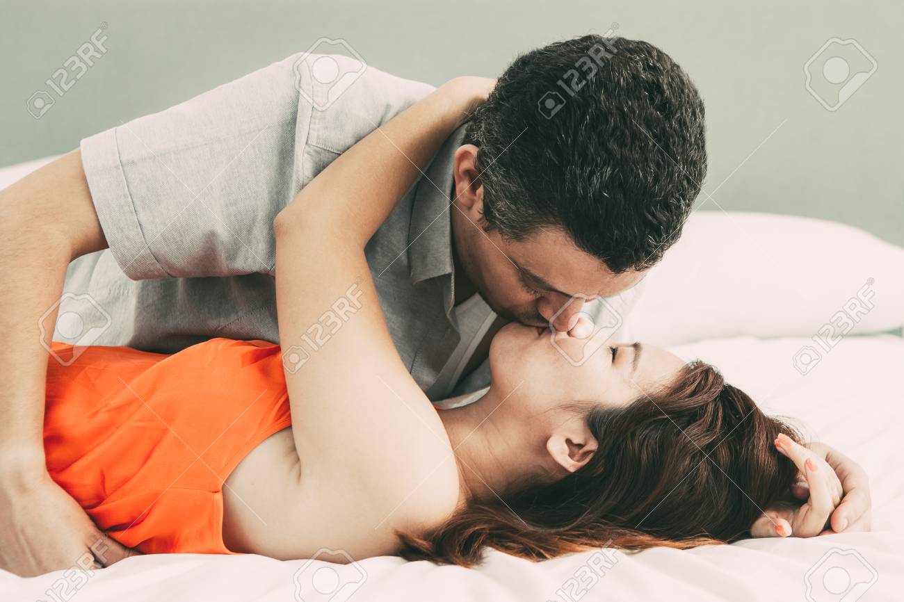 Passionate Couple Embracing and Kissing in Bed